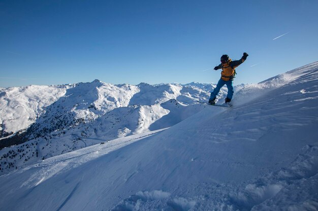 알프스의 큰 산 겨울에 아름다운 날에 스노보드 점프에 보더