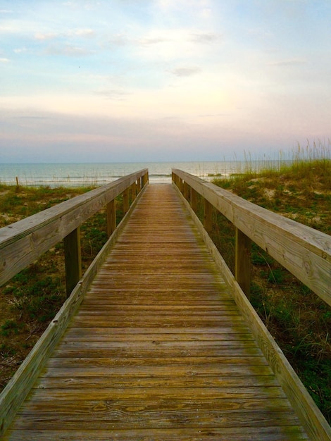 Foto passeggiata sulla spiaggia contro il cielo durante il tramonto