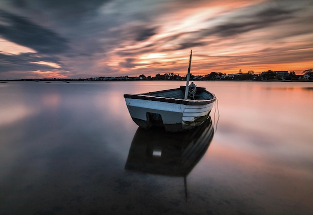 Фото Лодка на море против неба во время захода солнца