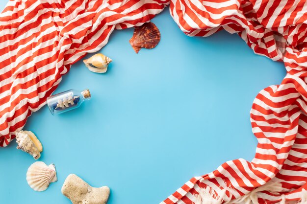 a boat in a bottle and seashells on a blue background