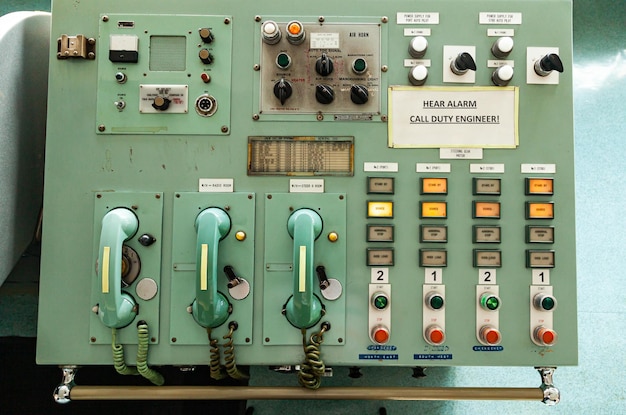Панель управления лодкой с аналоговыми проводными телефонами, кнопками-переключателями и сигнальными лампами