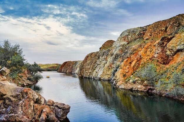 Photo boat driving on the river in the distance lake in the canyon in autumn mesmerizing landscape wallpapers