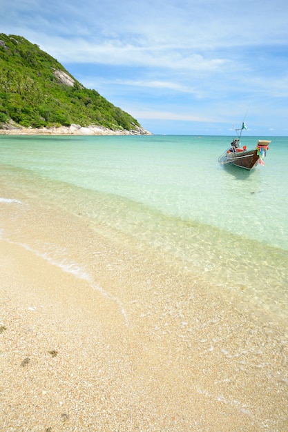 Лодка, плавающая на прозрачной воде, тропический пляж бирюзового моря в Таиланде