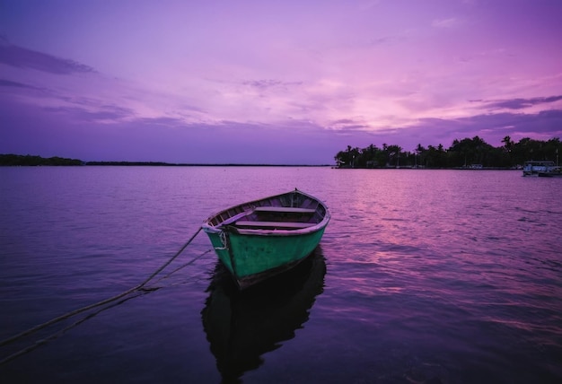 A boat gracefully navigating on the water against the backdrop of a mesmerizing purple sky