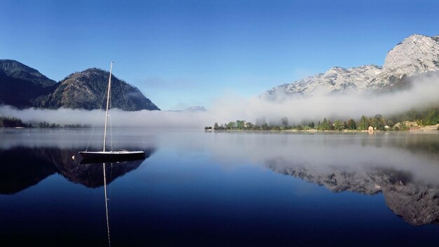 a boat is docked in a lake with a mountain in the background