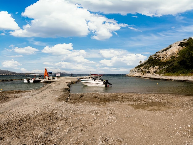 Лодка пришвартована в воде возле холма.