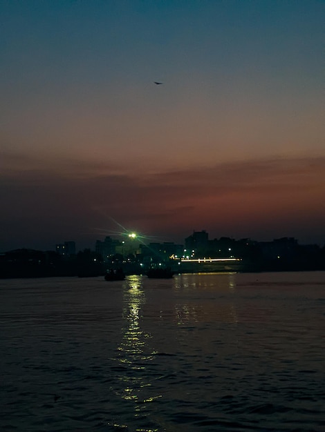 A boat is sailing in the water at night.