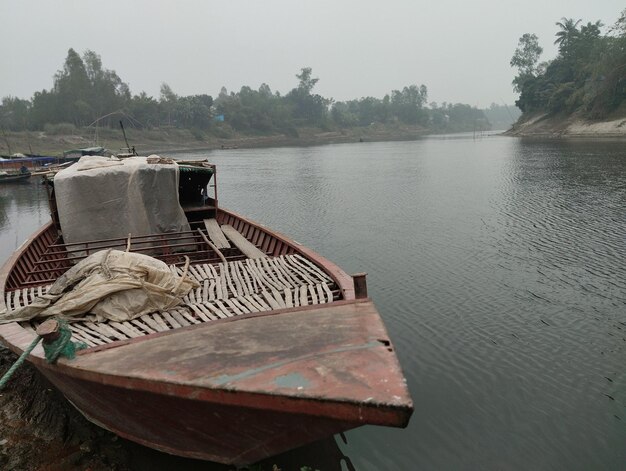 Photo a boat is tied with a rope to a hook on shore