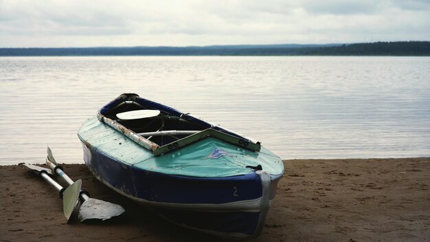 Photo boat or kayak moored on beach against sky