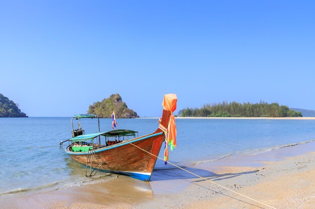 Boat moored on beach against clear sky