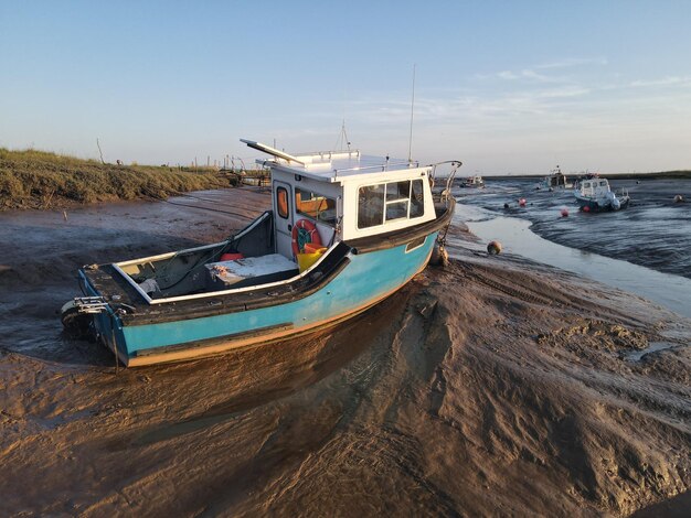 Photo boat moored on beach against sky