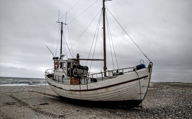 Photo boat moored on beach against sky