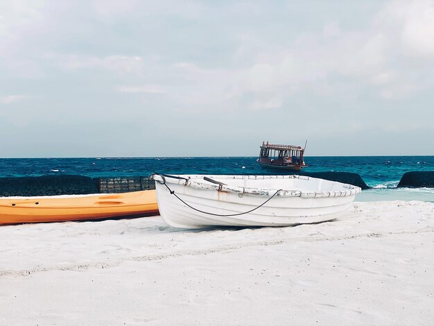 Boat moored on beach against sky