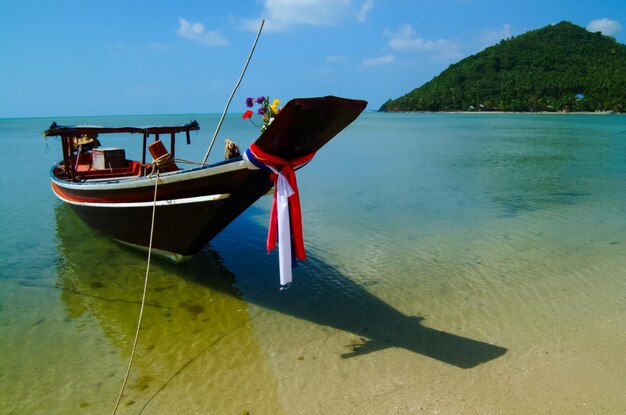 Boat moored on beach against sky