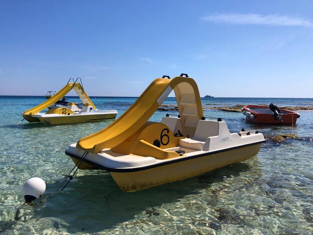 Boat moored on beach against sky