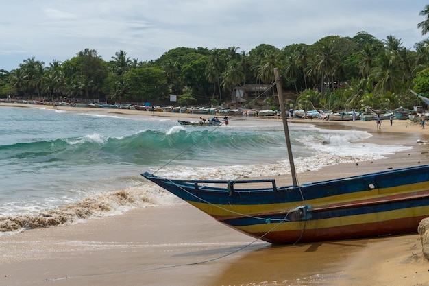 Boat moored on beach against sky