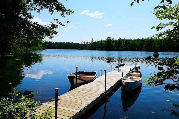 Boat moored by pier at lake