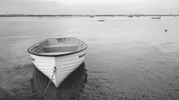 Boat moored at harbor against sky