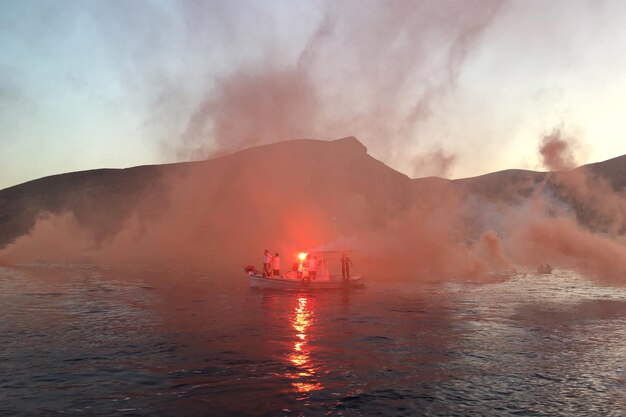 Photo boat moored on lake against sky during sunset