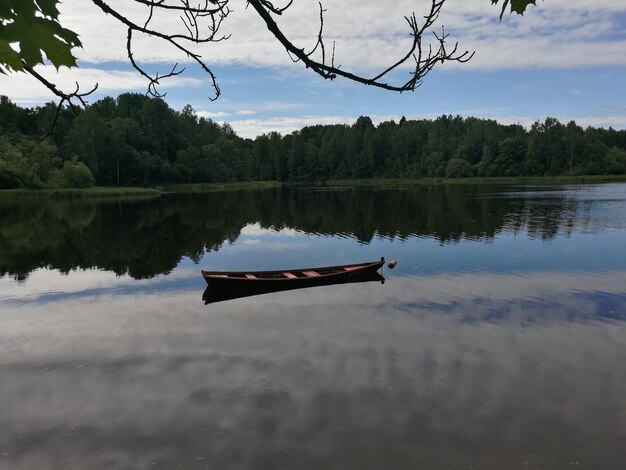 Boat moored on lake against sky