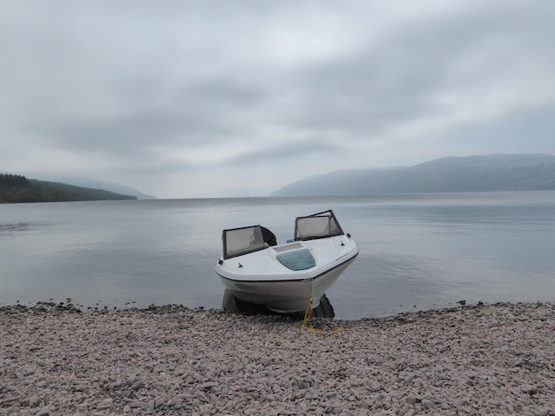 Photo boat moored on lake against sky