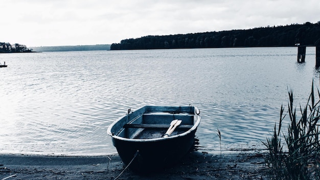 Photo boat moored on lake against sky