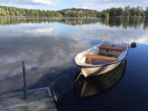 Photo boat moored in lake against sky