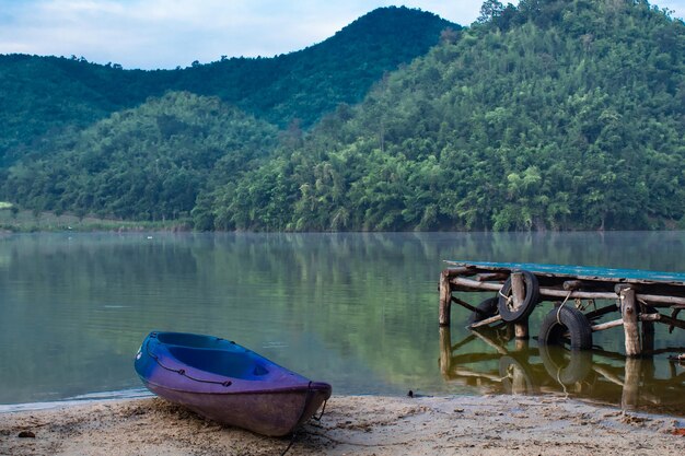 Foto barca ormeggiata sul lago contro gli alberi