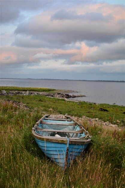 Boat moored on shore against sky