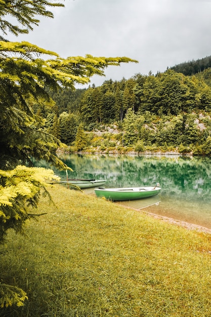 boat near coast on the lake in bavarian alps landscape with reflection in calm water in mountains