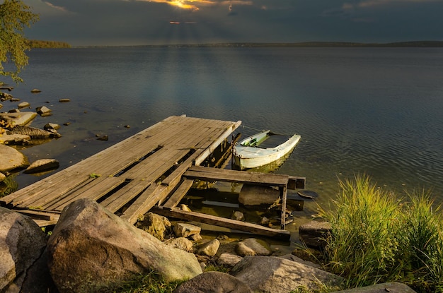 A boat near a wooden pier on the lake.