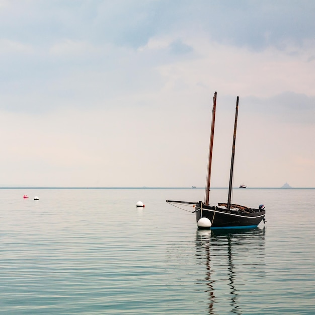 Cancale Brittany France의 잔잔한 바다에 반사된 보트