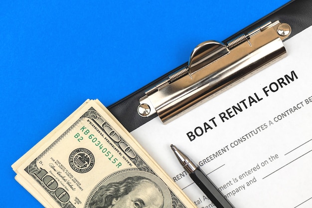 Boat rental form. Clipboard with official agreement, pen and money. Top view photo