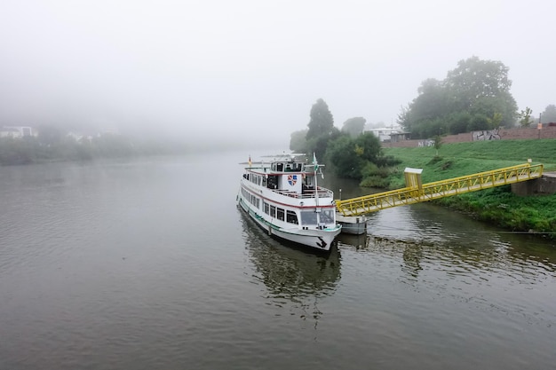 A boat on the river with a yellow ramp that says'river cruise'on it