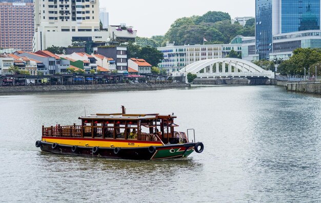 写真 都市の建物の近くの川で船が航海している