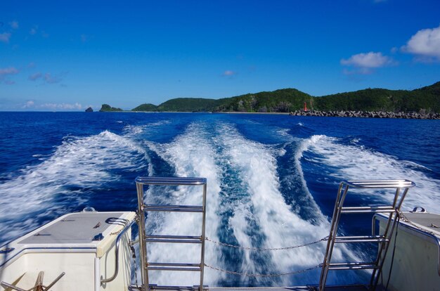 写真 青い空を背景に海を航海するボート