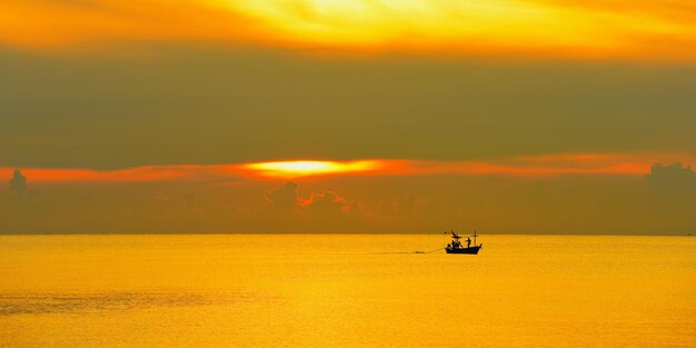 Boat sailing in sea against sky during sunset