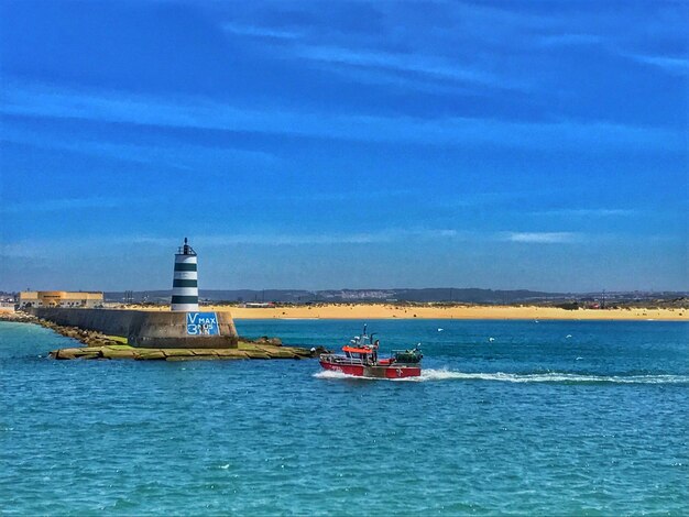 Boat sailing in sea against sky