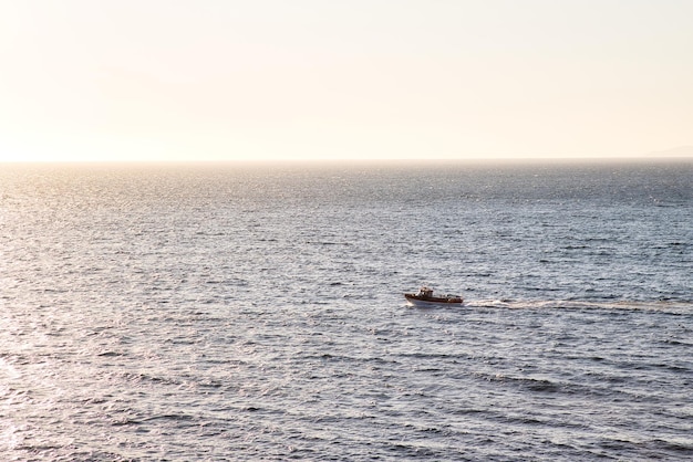 Boat sailing in the sea at sunset