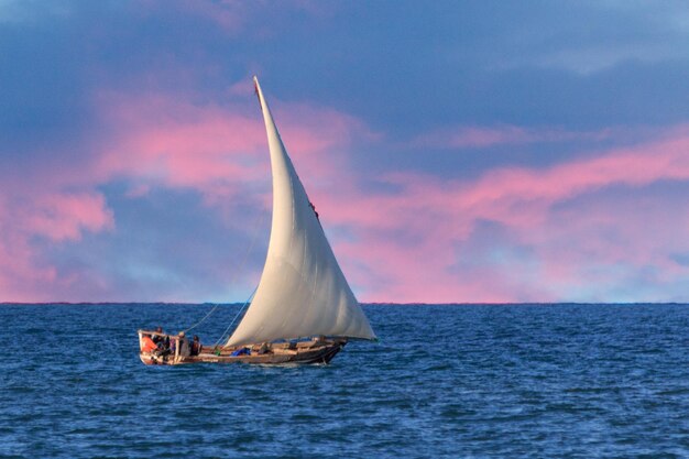 Boat in sea against sky during sunset