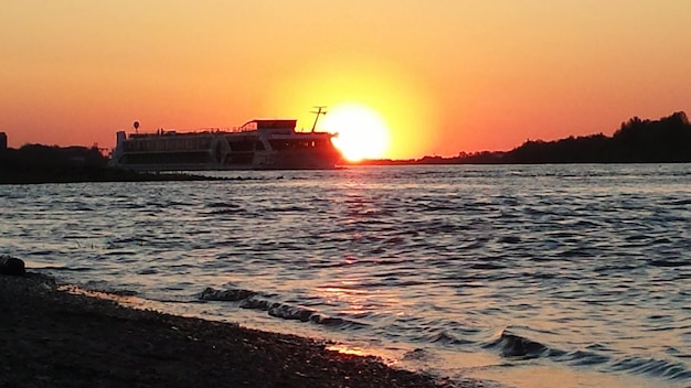 Boat on sea against sky during sunset