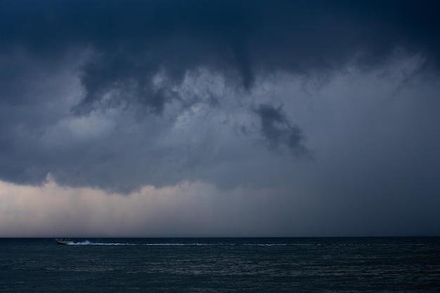 雲を背景に嵐の間に海でボート