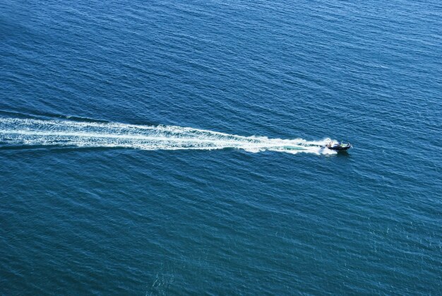 ウクライナ、クリミア半島の海岸の海の波の間でボート