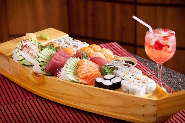 Boat of sushi with strawberry cocktail