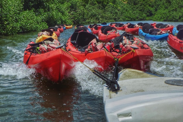 boat towing kayaks in river