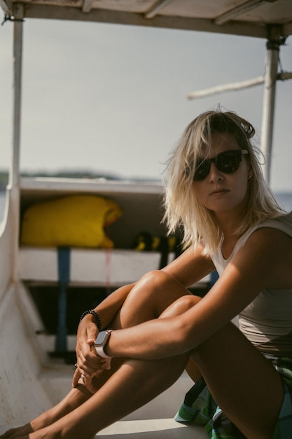 Boat trip in bali. a young woman in sunglasses is sailing on a\
boat to a nearby island.