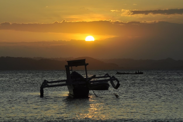 Foto una barca in acqua al tramonto