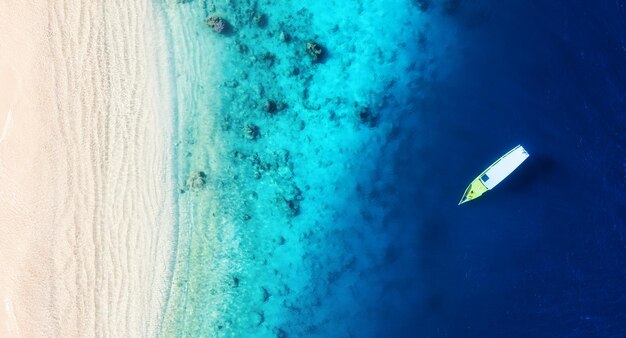 Boat on the water surface from top view Turquoise water background from top view Summer seascape from air Gili Meno island Indonesia Travel image