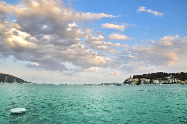 A boat in the water with a blue sky and clouds