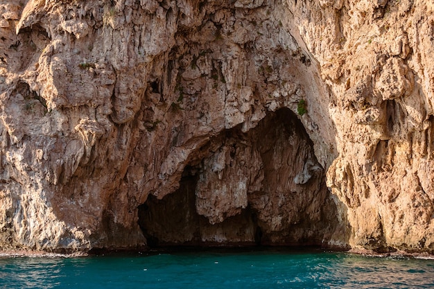 A boat in the water with a cave in the middle